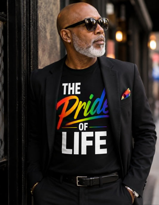 Man wearing a black t-shirt with 'The Pride of Life' text and rainbow colors, standing against a blurred street background.